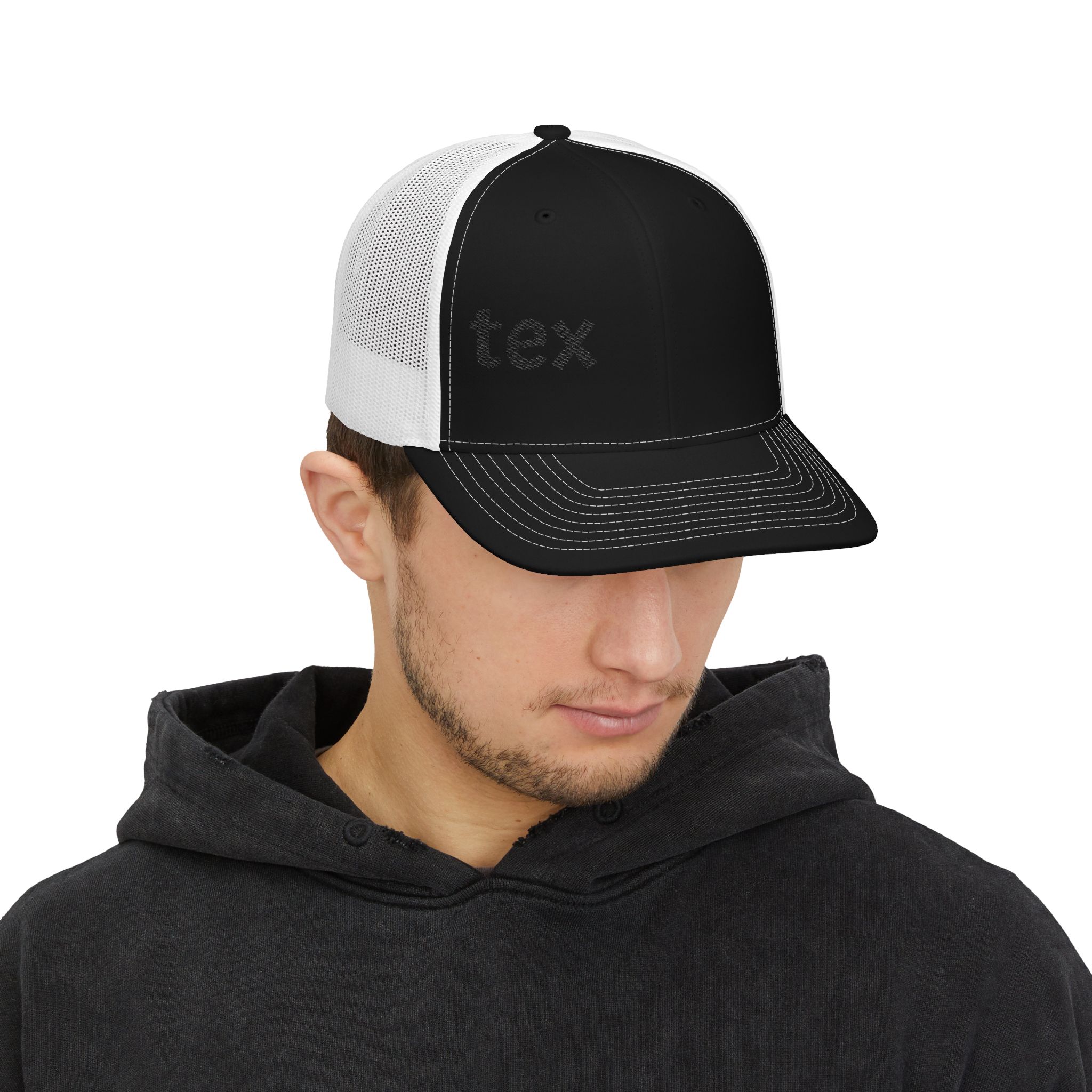 A man in a dark hoodie looks down, wearing the Embroidered Trucker Snapback Cap — Classic Mesh Baseball Hat with a black and white design, mesh back, faint front text, and set against a plain white background.