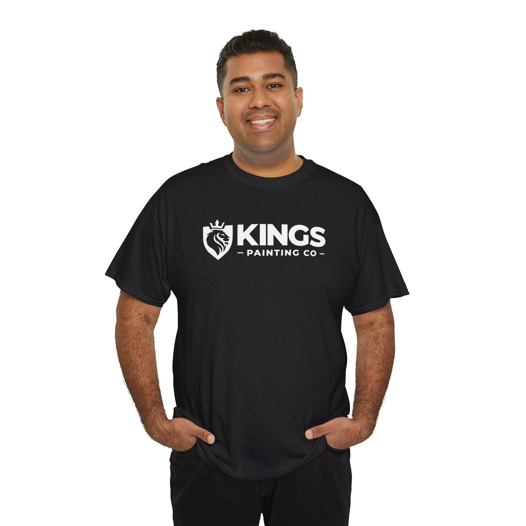A smiling man with short dark hair stands with his hands in his pockets against a plain white background, wearing the Kings Painting Co. Logo T‑Shirt (Classic) on a Gildan Ultra Cotton (G5000) in black.