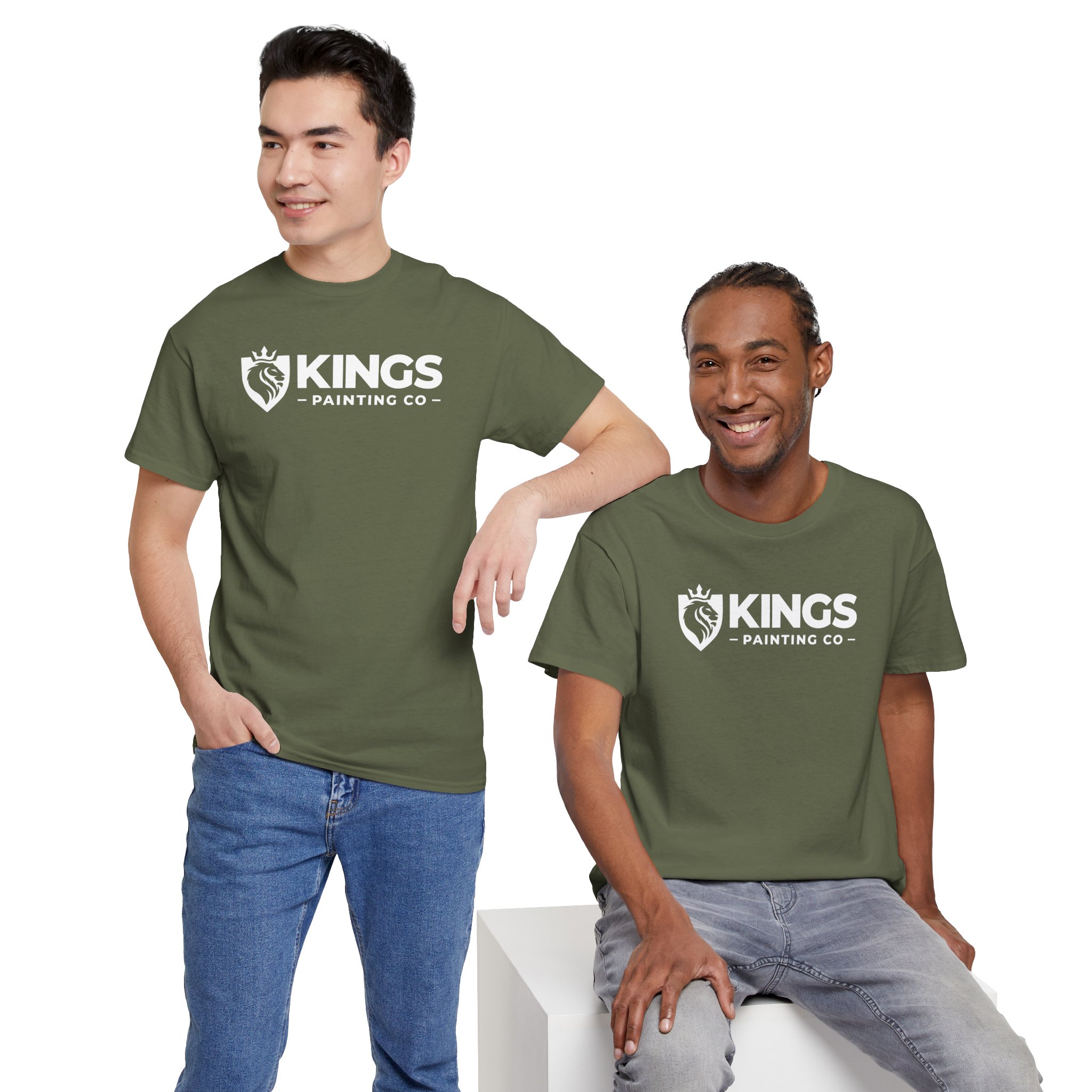 Two men smiling, both wearing matching Kings Painting Co. Logo T‑Shirts (Classic) on Gildan Ultra Cotton (G5000), featuring a crown and paintbrush logo in olive green. One stands with a hand in his pocket while the other sits casually on a white block.