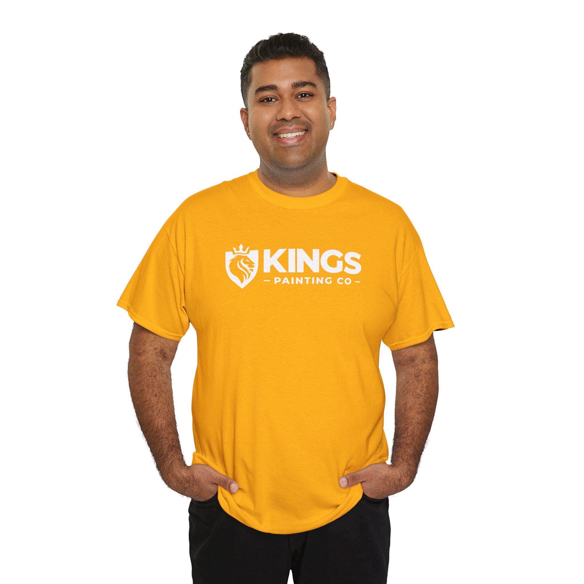 A smiling person stands with hands in pockets against a white background, wearing the Kings Painting Co. Logo T‑Shirt (Classic) on Gildan Ultra Cotton (G5000) in bright yellow, featuring the KINGS PAINTING CO. logo and emblem.